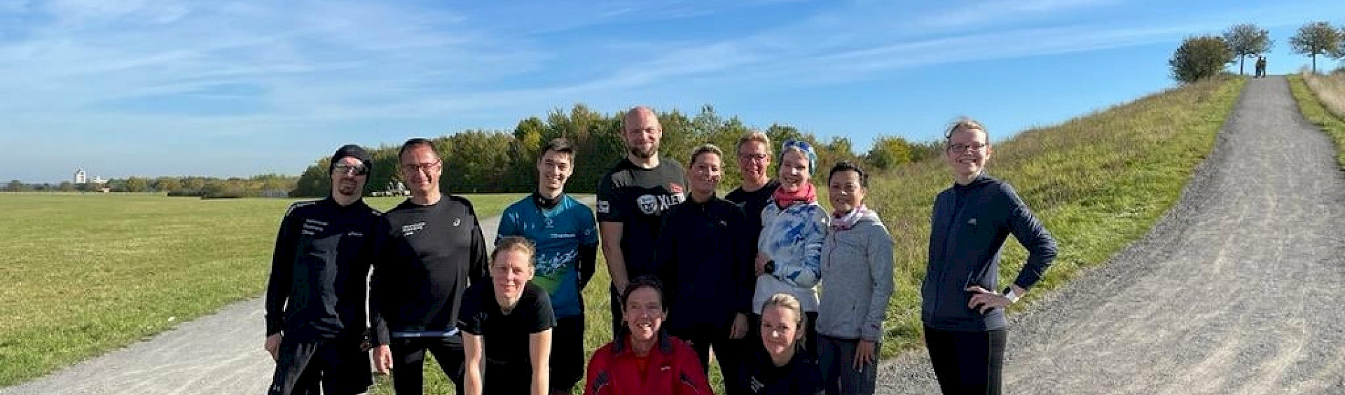 Eine Gruppe an Teilnehmern des Höhentrainings für den Marienburg-Marathon steht am Fuß eines Hügels